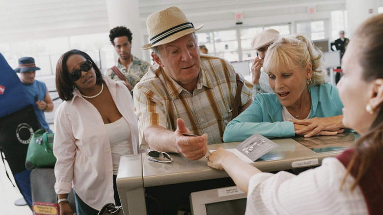 a group of passengers at an airline counter