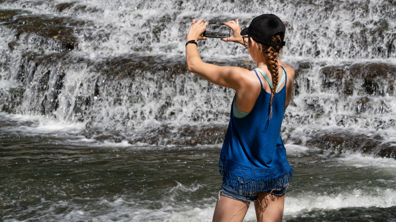 Woman photographing a cascade at Burgess Falls SP