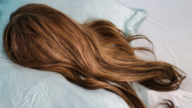 A brownish wig on a pillow