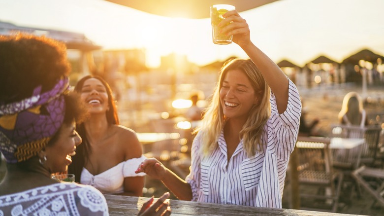 women drinking near beach