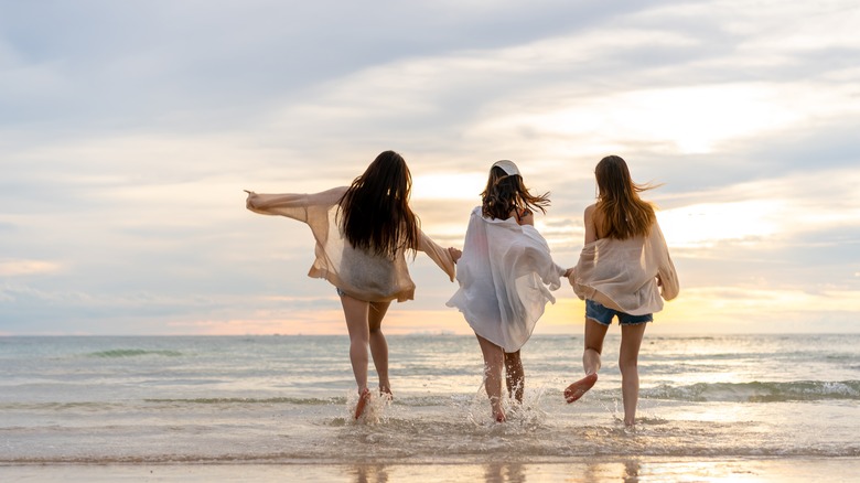 Friends walking into the ocean