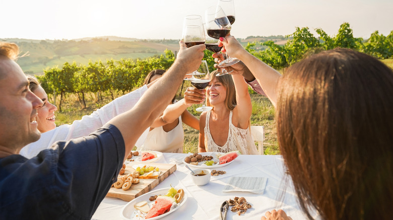 Patrons at a French winery raise their wine glasses