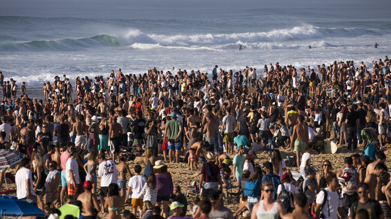 A crowd on the beach watching a surfing competition