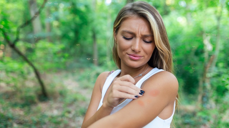 woman grimacing at bug bite
