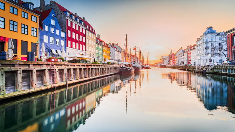 Copenhagen, Denmark at Nyhavn. Iconic canal, colorful sunrise, and breathtaking water reflections.