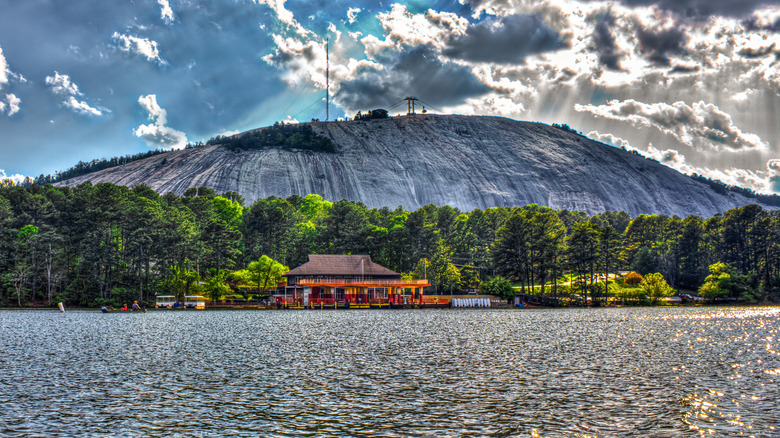 Stone Mountain in front of a lake and lush green trees