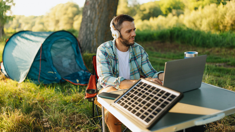 man on laptop at campsite