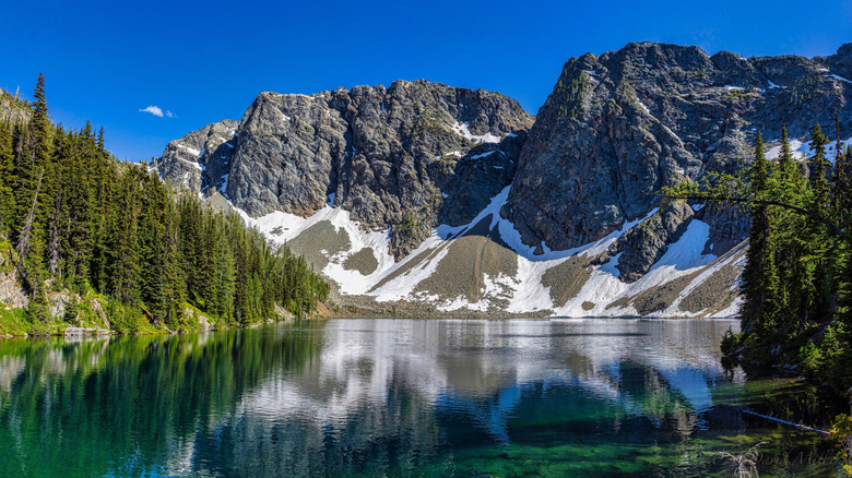 A clear lake surrounded by rocky mountains