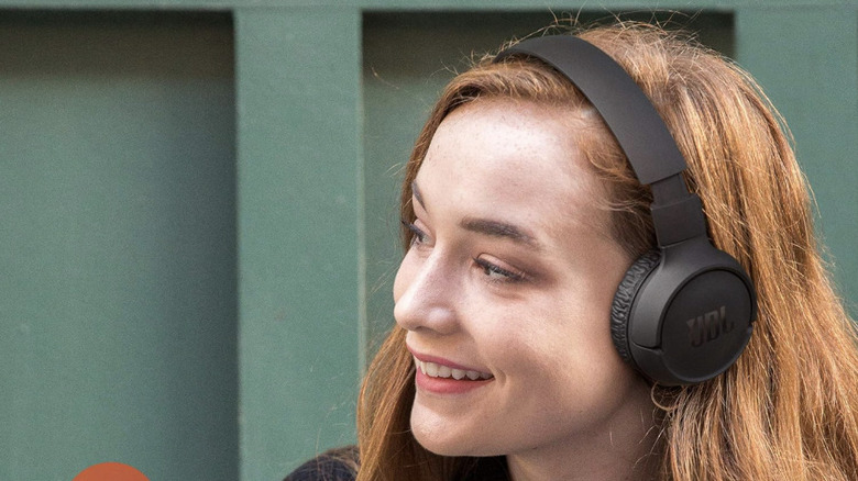 A woman wearing the JBL Tune headphones in black.