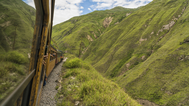 A train moves along a steep cliff in Ecuador