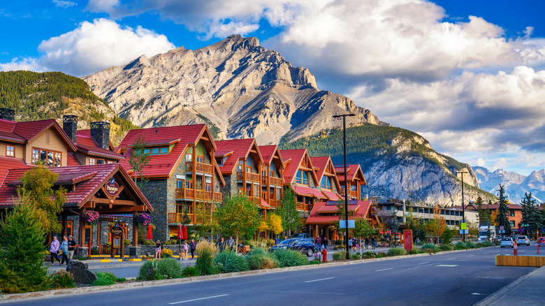crimson-roofed buildings lined along a street set against a backdrop of mountains