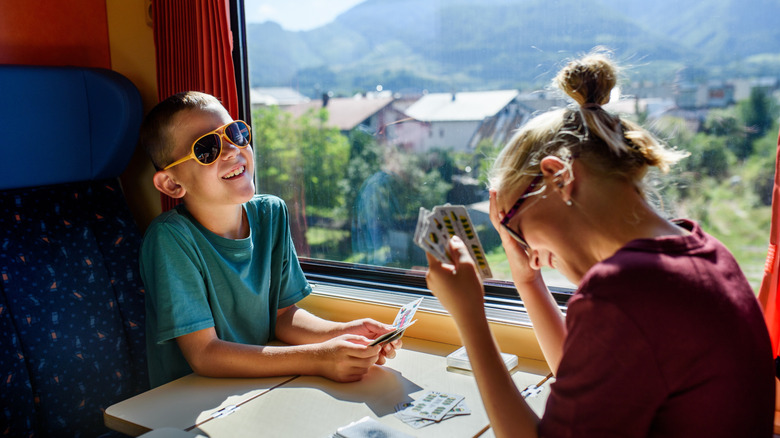 siblings playing cards on a train