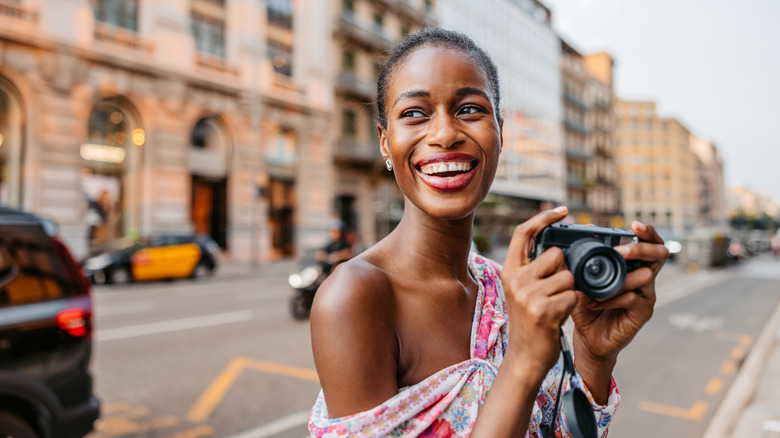 smiling traveler with film camera