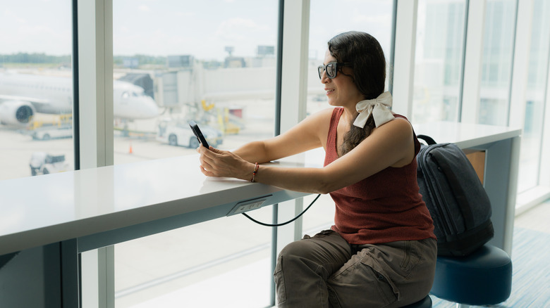 Woman using phone in airport