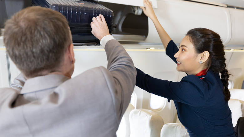 flight attendant helping passenger