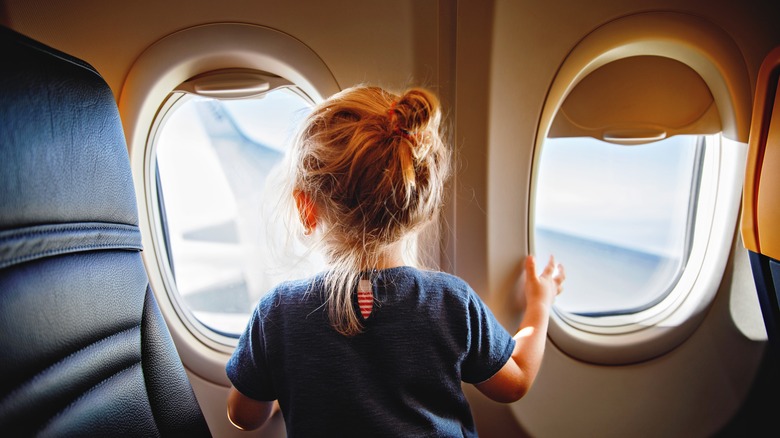 Child looking out plane window