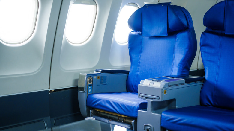 empty blue seats near airplane windows