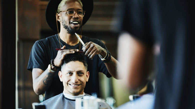 Barber giving client a haircut