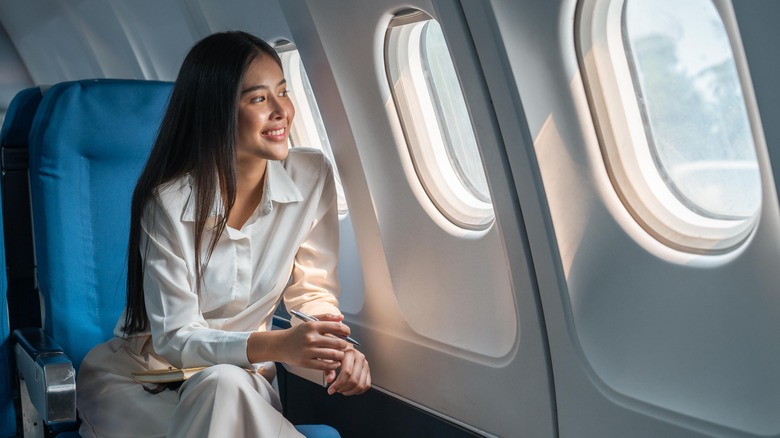 Woman looks out plane window