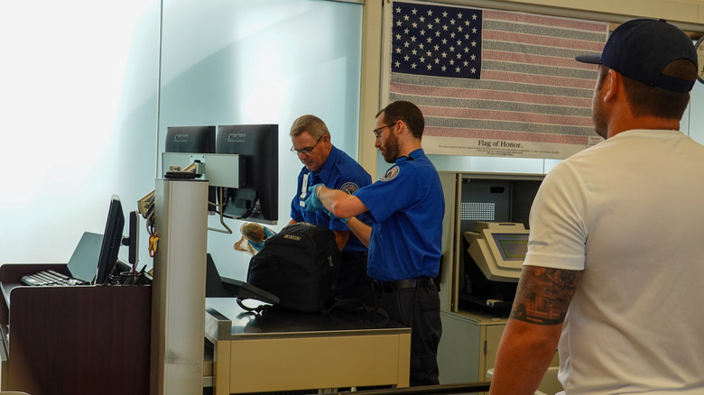 two security officers checking bag at TSA security check point