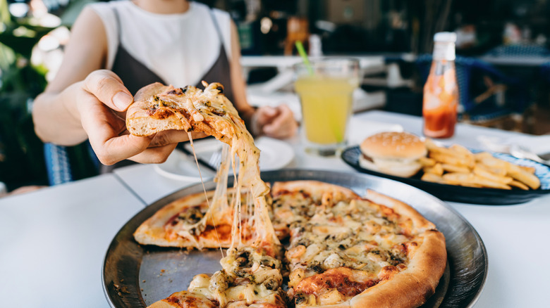 Woman eating pizza in restaurant