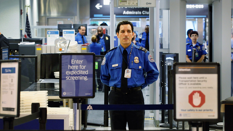 TSA agent waits for passengers for screening
