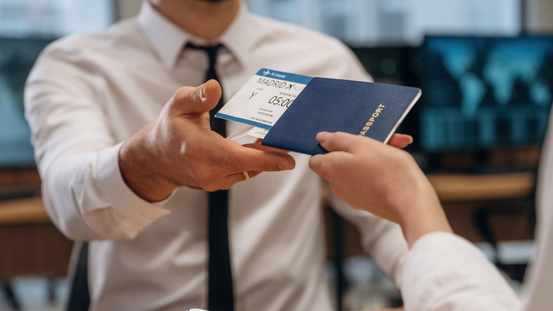 airline employee handing boarding pass to passenger