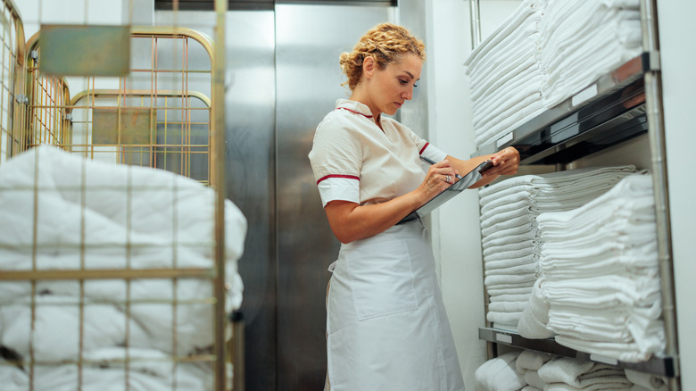 woman in hotel laundry room with towels