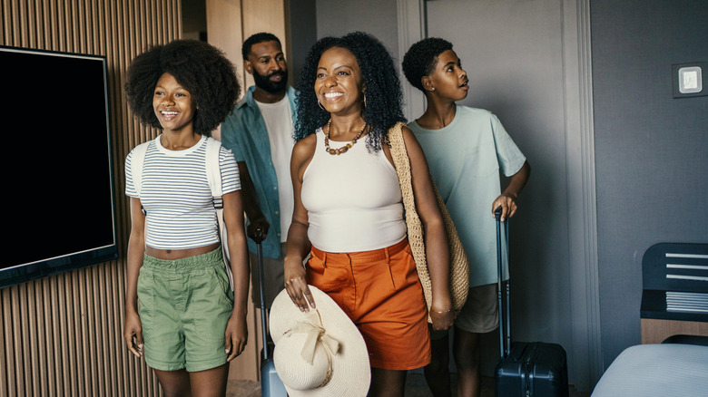 family arriving in hotel room