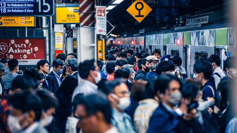 A busy metro stop in Tokyo full of commuters