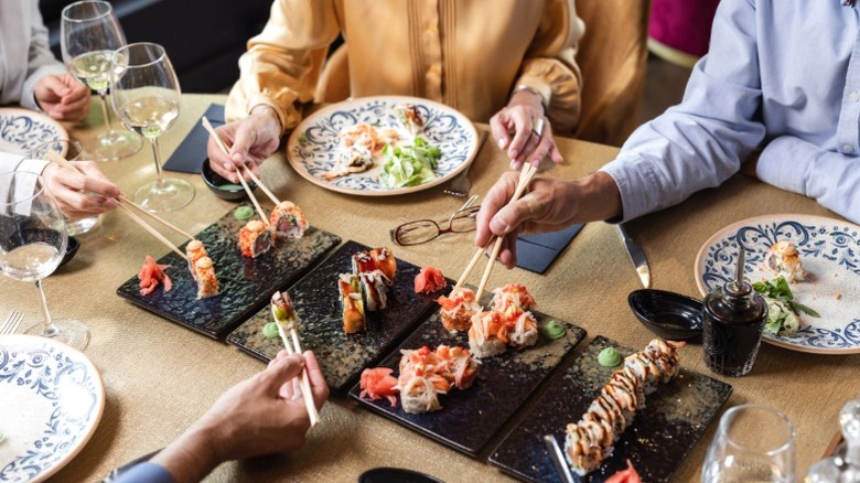 cheerful woman using chopsticks to eat in a pot meal
