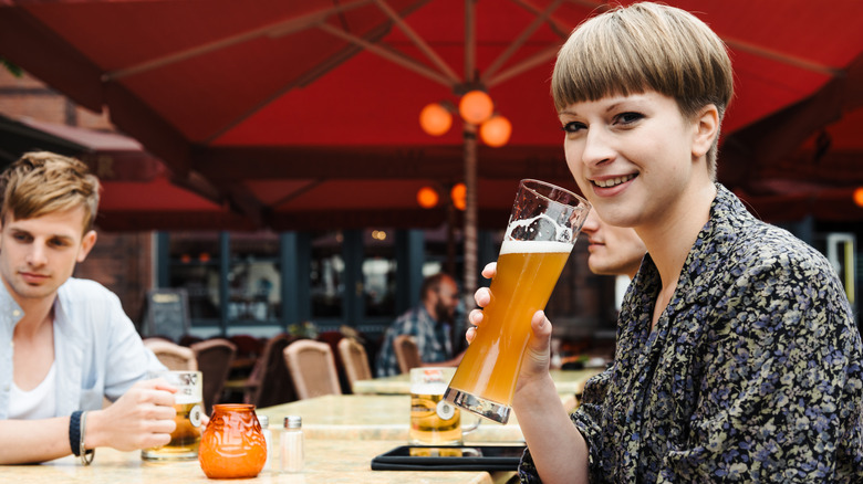 A woman holding a glass of beer
