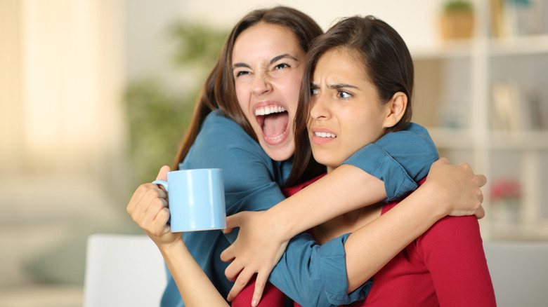 Excited woman hugging an awkward friend