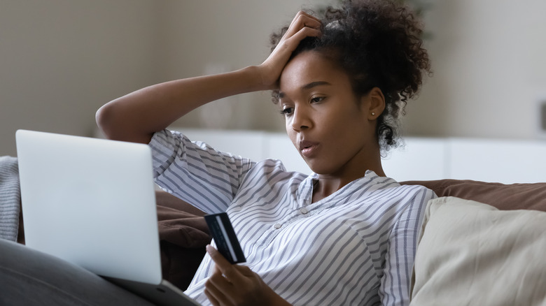 Stressed woman holding credit card