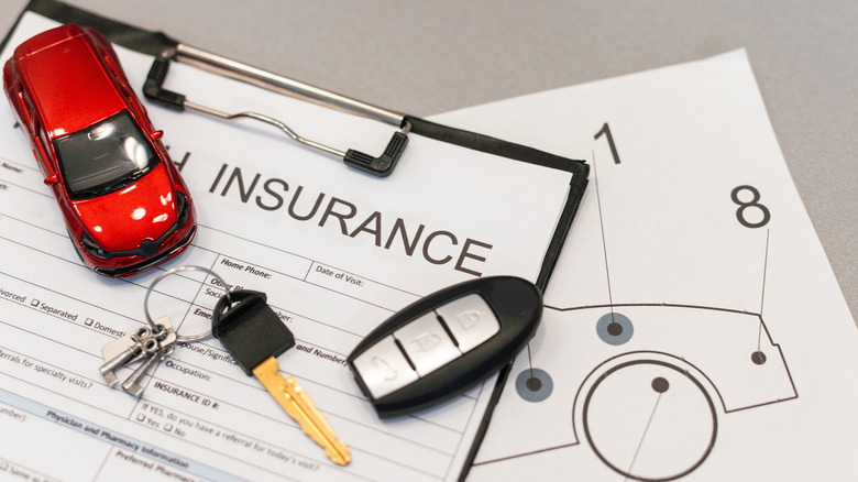 A white insurance form with car keys