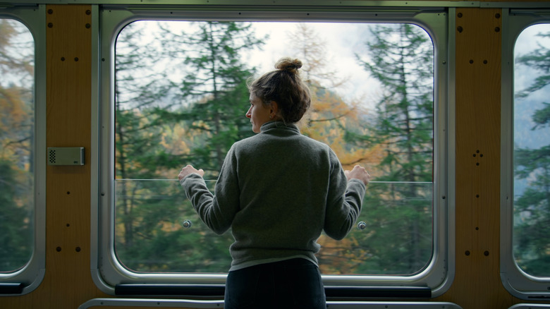 A woman looking out a train window.