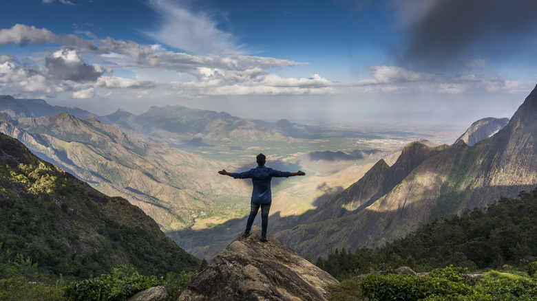 A man stands on a mountain in Kolukkumalai, India