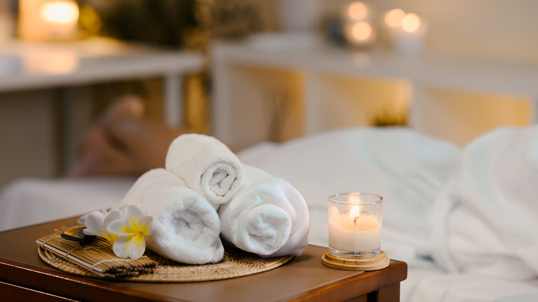 Towels rolled on table with lit candle
