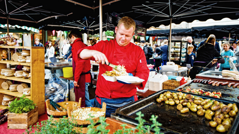 Market vendor preparing take-out food at Covent Garden Market, London.