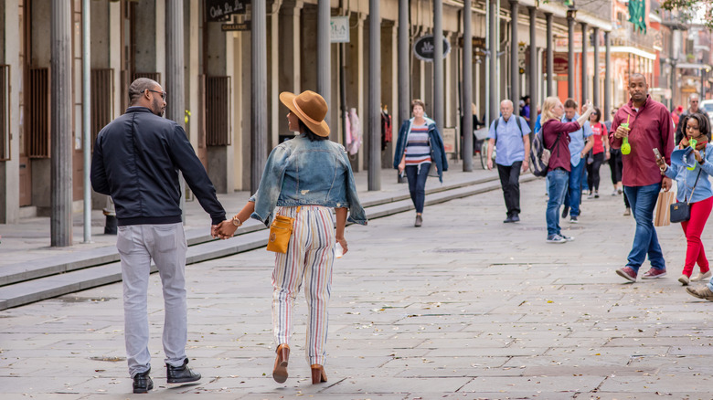 A couple strolls on a New Orleans street.