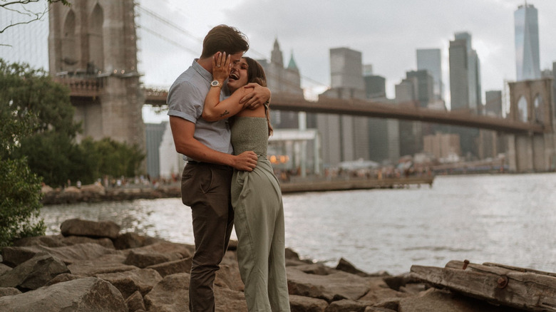 A happy couple in front of New York City's Brooklyn Bridge.