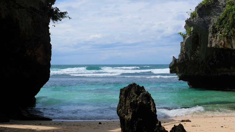 The waves crash on the shores of Blue Point Beach in Bali, Indonesia