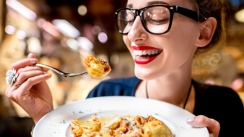 Woman eating tortellini bolognese 