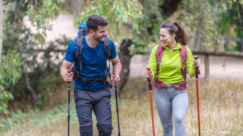 couple hiking with poles