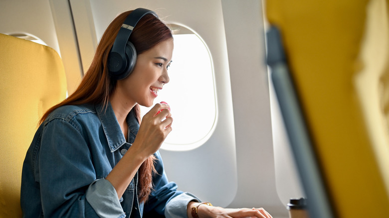 A woman enjoying a snack on a plane