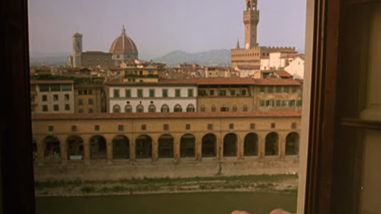 a view of the terracotta rooftops in Florence through a window from A Room With a View