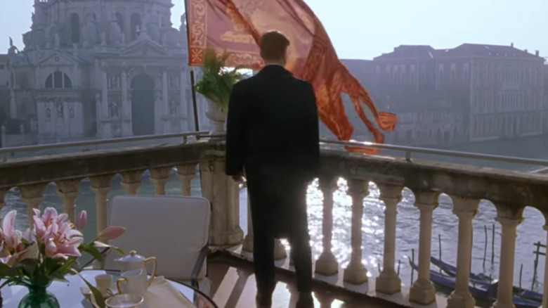 A still from the film The Talented Mr Ripley with a balcony scene overlooking historic buildings next to the lake