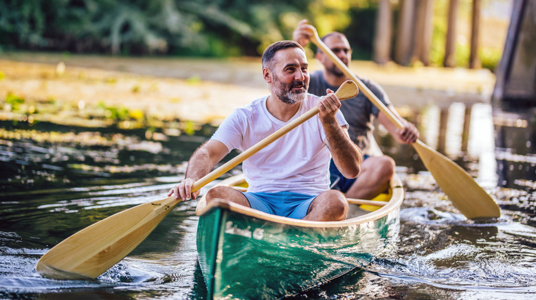 Two men paddling a canoe on lake