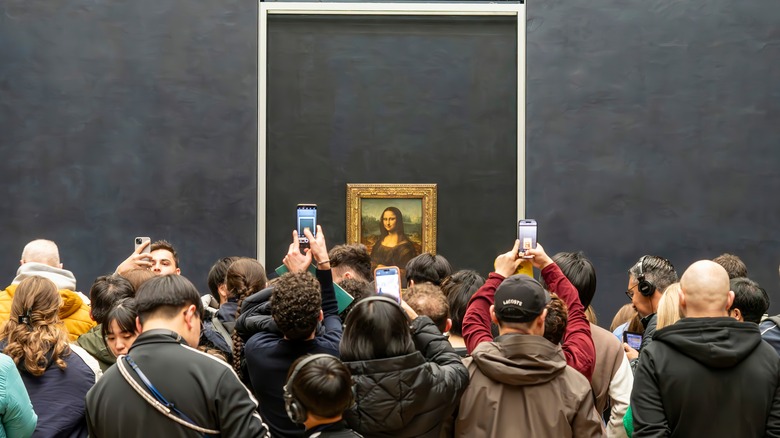 People packed together looking at the Mona Lisa