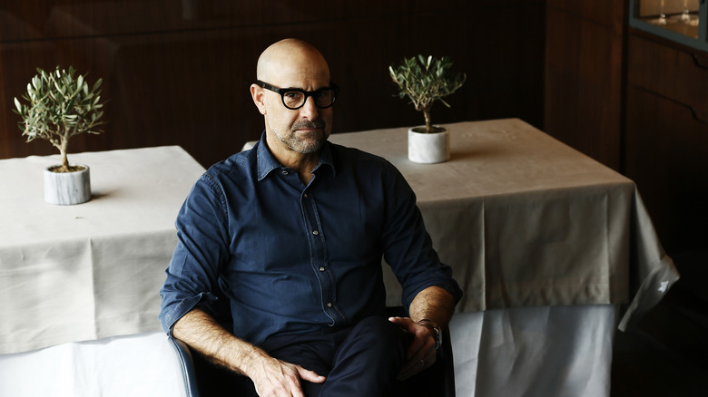 Stanley Tucci sitting at table